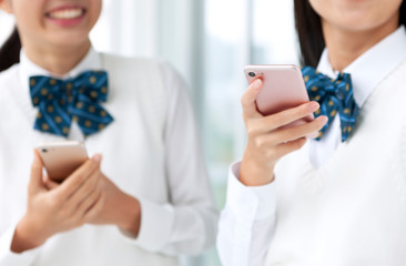 スマートフォンを持つ女子学生の手元