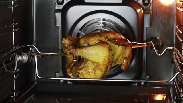 oven. grilled chicken is cooked on a spit. it gradually rotates on the vertical