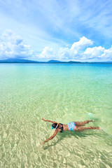 Fototapeta na wymiar Black woman in bikini snorkeling in crystal clear water in El Nido - Palawan - Philippines