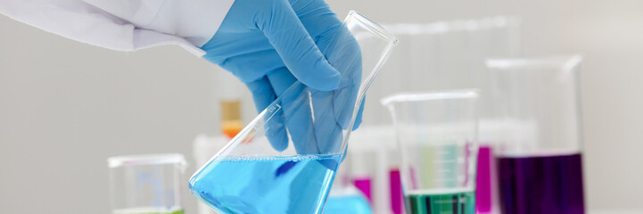 A male chemist holds test tube of glass in