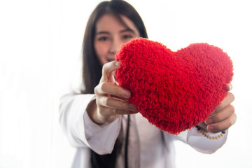 Doctors hold a heart-shaped pillow instead of health care.Heart disease must be taken care of. In order to have a healthy body.