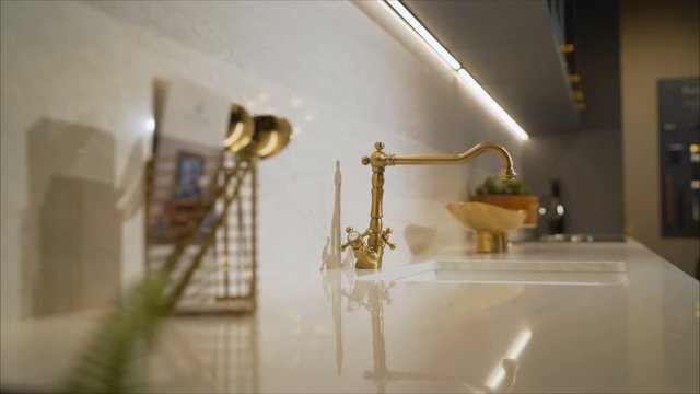 Golden washbasin faucet in the kitchen. golden design sink and washbasin retro vintage decorated luxurious kitchen interior