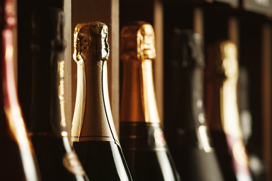 Underground cellar with elite sparkling wine on shelves, close up horizontal photo.