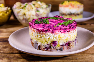 Set of festive mayonnaise salads on wooden table