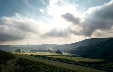 Bright Sunlight coming through clouds over Coquetdale countryside in Northumberland, North East...