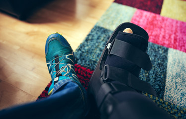 A plastic boot offering protection to a broken right ankle from trail running.