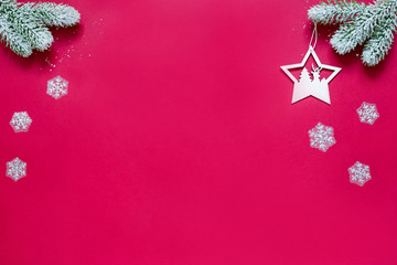 Snowy sprigs of pine, snowflakes and star with silhouette of a christmas tree and deer isolated on red background.