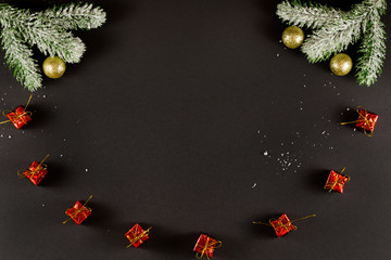 Group of christmas gifts, golden christmas balls and snowy sprigs of pine isolated on black background.