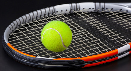 tennis racket and ball on black background