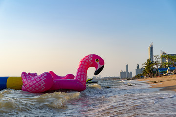 Pink Flamingo Mattress on the Beach. Holiday Concept Background