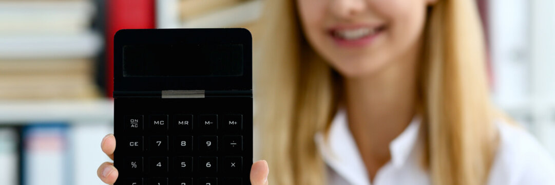 Smiling businesswoman portrait holds calculator in han
