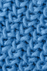 Blue knitted fabric closeup. Knitted wool background. Handmade.