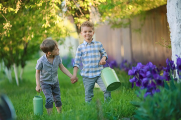 Fototapeta premium Two handsome brothers having fun while sitting outside in garden.