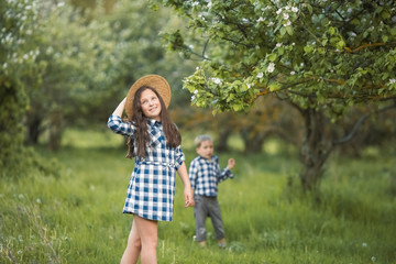brother and sister walking in the grass.