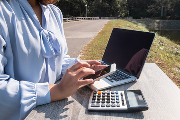 Close-up Of  Young businesswomen working on smartphone and laptop for online searching
