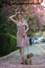 Blonde model with elegant hat on her head during a walk in the city Park.