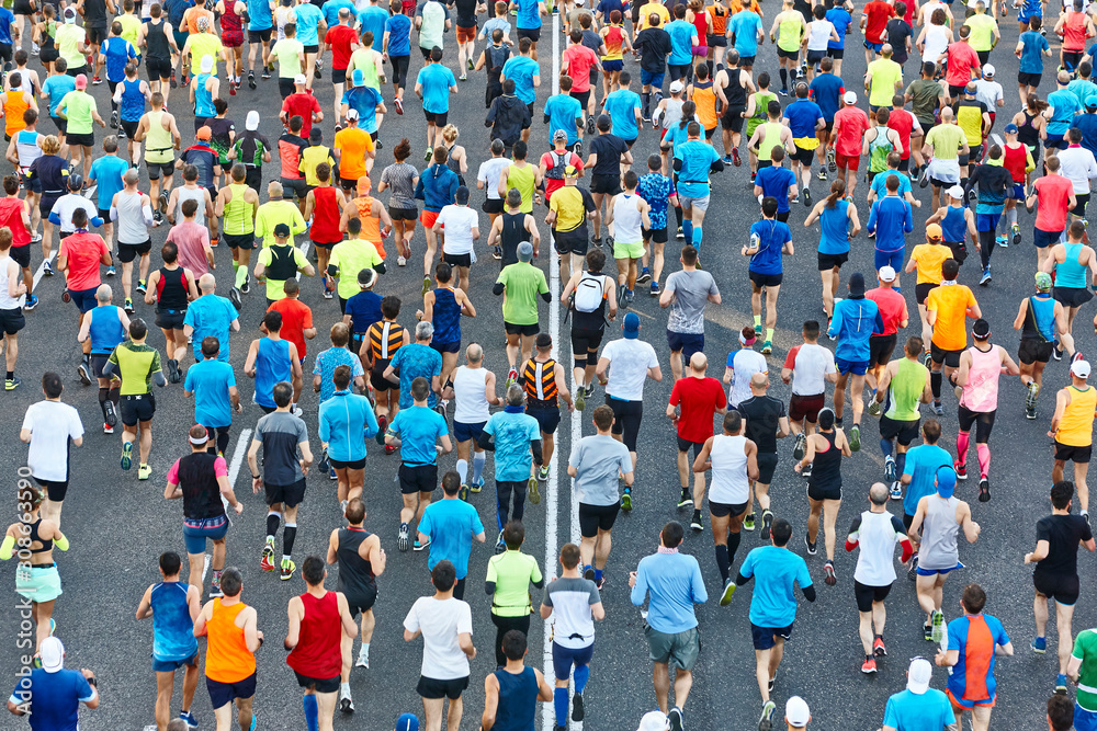 Wall mural runners on the street. athletes in motion. urban competition. crowd