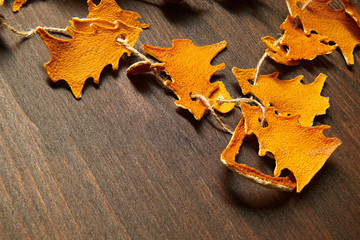 Obraz premium Christmas and new year holiday concept with copy space - handmade decoration from dried peel of oranges in a fir tree shape on a dark wood background