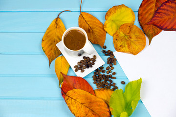 Naklejka na ściany i meble autumn leaves smell coffee and drink a cup of turkish coffee Top view autumn composition a wooden blue background for design. White paper beautiful writing pen dried tree leaves 