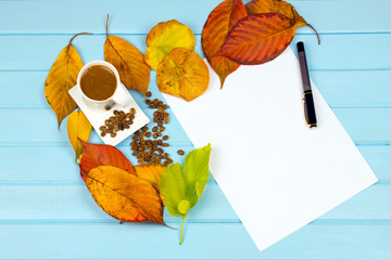 Naklejka na ściany i meble autumn leaves smell coffee and drink a cup of turkish coffee Top view autumn composition a wooden blue background for design. White paper beautiful writing pen dried tree leaves 