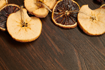 Handmade decoration from dried fruits on a dark wood background with copy space. Top view.