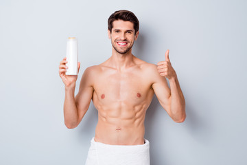 Fototapeta premium Portrait of his he nice attractive bearded cheerful brown-haired guy holding in hand new shower gel treatment therapy showing thumbup isolated on light white grey color pastel background