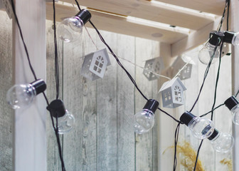 white wooden shelving on a light background with lamps and decorative loft houses