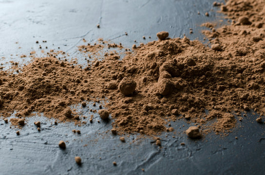 Closeup of heap of cococa powder on the dark surface