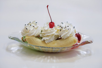 fresh Banana Split Ice Cream in a boat shaped glass cup on white table background,food, copy space