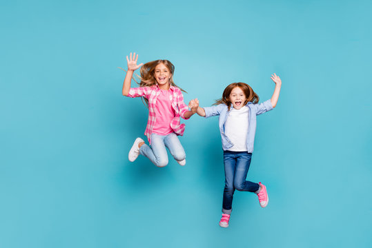 Full length body size photo of two excited cheerful overjoyed optimistic girls wearing jeans denim white while isolated with blue background