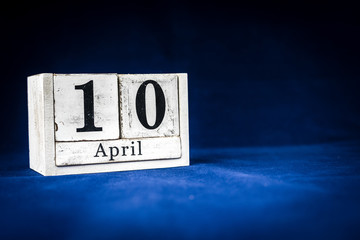 April 10th, Tenth of April, Day 10 of month April - rustic wooden white calendar blocks on dark...