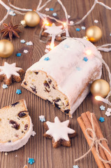 traditional german christmas cake stollen with cookies and decoration on wooden table