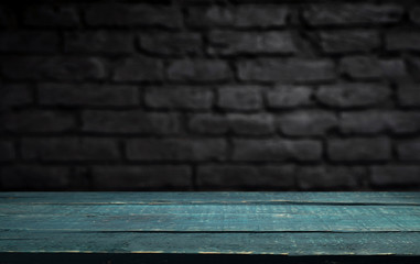Wood table in front of rustic brick wall blur background with empty copy space on the table for product display mockup. Retro design montage presentation.