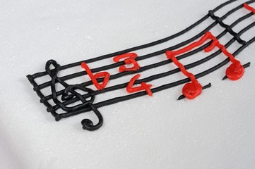 Fototapeta premium White birthday cake with musical stave on top.