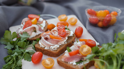 toasts with curd cheese, bacon, herbs and tomatoes