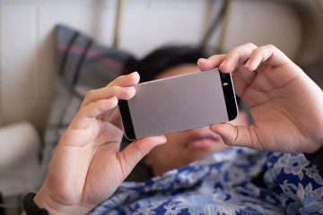boy Holding the phone to sleep on the bed