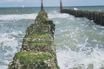 Keuken spatwand met foto Close up beach poles splashed by water at the sea coast © fotografiecor