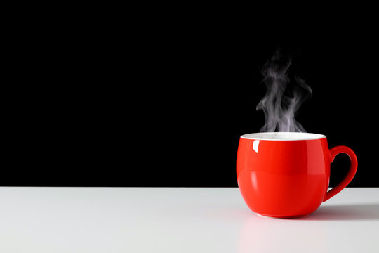 Steaming Coffee Cup On Black Background. Red сoffee Cup With Steam. Smoke From Hot Coffee. Front View, Copy Space