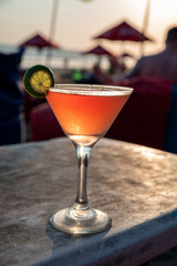 orange cocktail on a beach table top