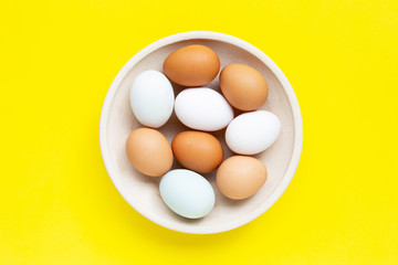 Fresh eggs on yellow background.