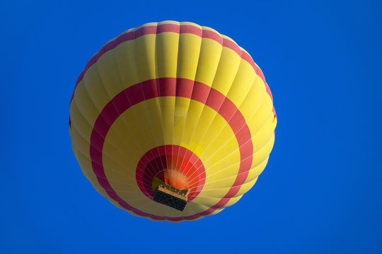 Yellow And Red Hot Air Baloon Flying In Blue Sky