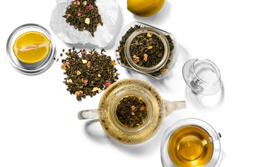 Tea, teapot, spoon and lemon on a white background