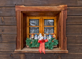 Christmas decoration dolls at the window made of wood