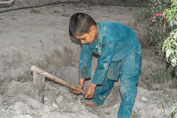 a very young orphan child is forced into child labor and working at a construction site and his...