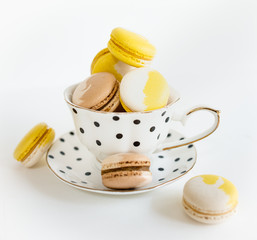 Cup and macaron or macaroon on wooden table