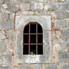 Fototapeta na wymiar window with bars in the old wall, background