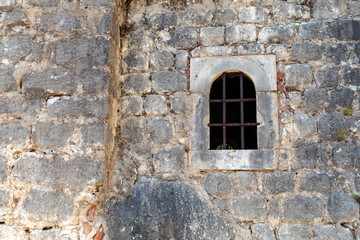 Fototapeta na wymiar window with bars in the old wall, background