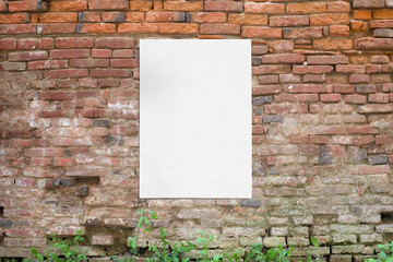 Poster glued to old brick wall. Blank, clean white paper for mockup, design presentation