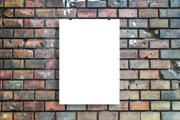 Blank poster hangs in front of urban brick street wall mockup