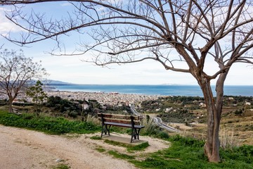 The view from lookout above the Patras city in Greece with a tree and a bench to relax and admire the beautiful cityscape